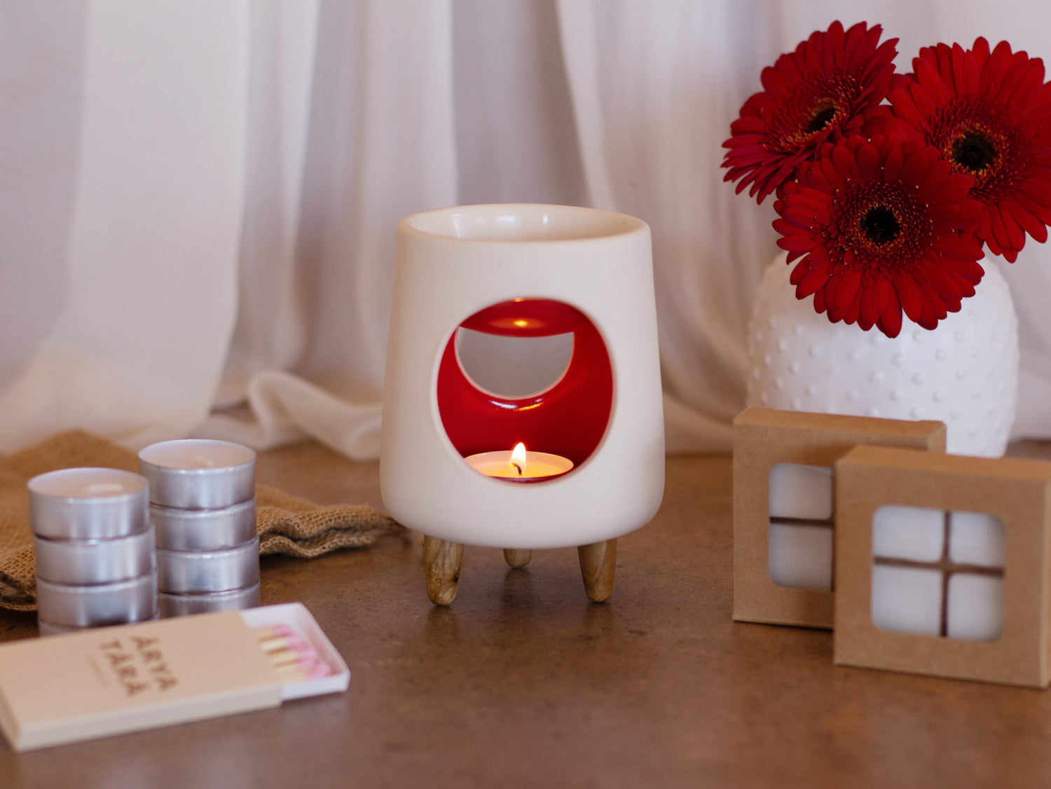 Ceramic wax warmer essential oil warmer by Arya Tara Candles. White outside red inside colored. Ceramic handmade tealight wax warmer with wooden legs.