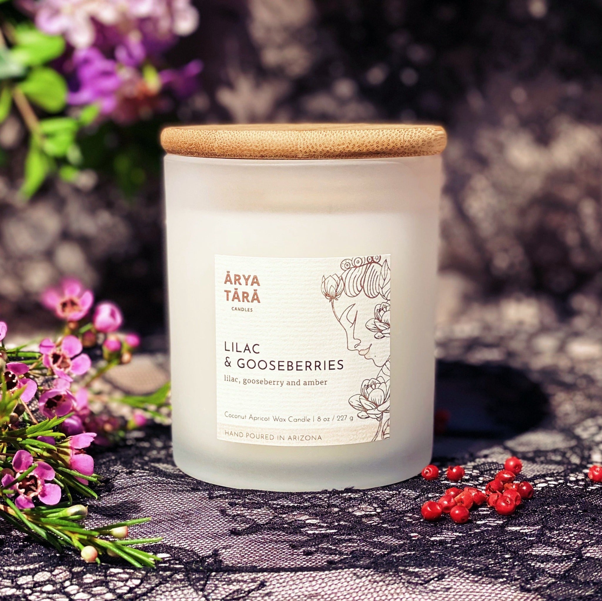 Lilac and Gooseberries Candle by Arya Tara Candles. Lilac, gooseberries, pink peppercorn, vanilla, patchouli, amber. Witcher fandom candle, Yennefer perfume, Yennefer scent, Witcher themed candle, Witcher scents. Non-toxic natural candle made with coconut apricot wax, lead-free zinc-free wicks, premium fragrances. Luxury candle, natural candle. Made in Tucson Arizona, hand poured candle in small batch. Glass white jar with bamboo wooden lid. 
